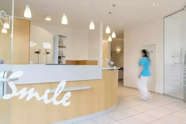 Heller Empfangsbereich einer Zahnarztpraxis mit moderner Einrichtung und freundlicher Atmosphäre.